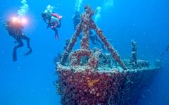 In this Sunday, May 15, 2022, photo provided by the Florida Keys News Bureau, divers swim near the bow of the retired Naval Landing Ship Dock Spiegel Grove, sunk 20 years earlier, six miles off Key Largo, Fla., to become an artificial reef. The vessel's storied past is to be celebrated May 17, 2022, the 20th anniversary of the sinking, with an event at a local cultural center that features key individuals reminiscing about the project. (Frazier Nivens/Florida Keys News Bureau via AP)