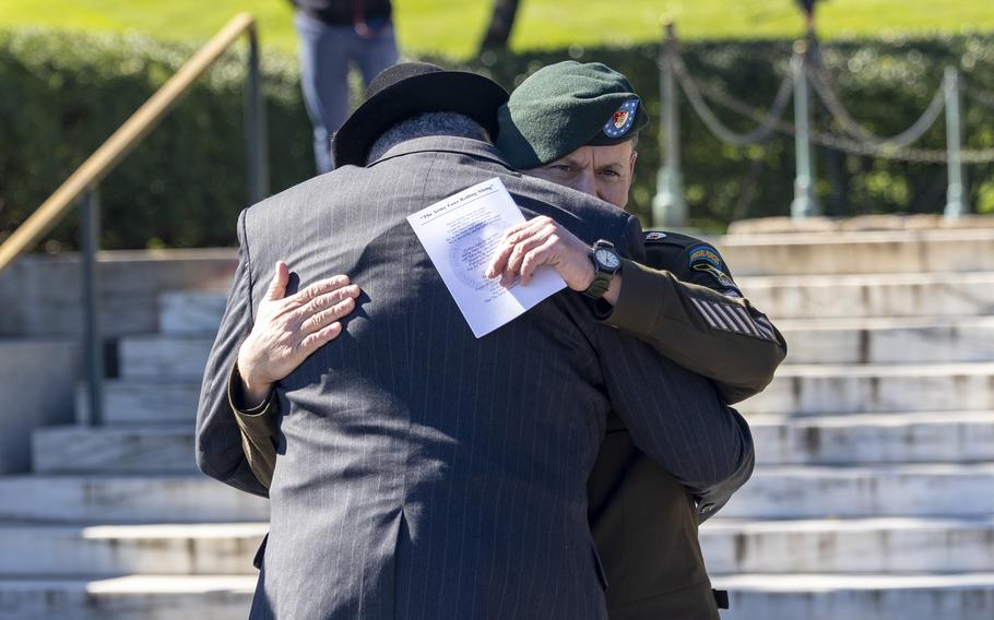 Two men embrace at a wreath-laying ceremony at Arlington National Cemetery, Va., on Oct. 17, 2024.