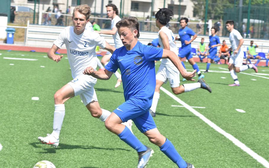 Black Forest Academy's Kody Mishler matches Ramstein's Jayden Andrews as he rushes up the field Wednesday, May 18, 2022, at the DODEA-Europe boys Division I semfinals at Ramstein Air Base, Germany.