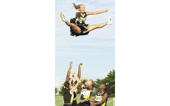 Kadena Air Base, Okinawa, Sept. 17, 2004: Kadena Panthers junior cheerleader Stacey Ware goes airborne during a stunt during halftime activities in Okinawa Activities Council season-opening football game at Kadena High School.

META TAGS: DODDS; sports; cheer; high school; Department of Defense Dependent Schools; DODEA; military brats; football