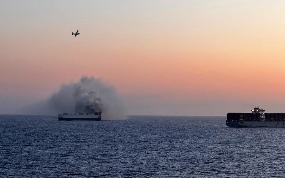 Smoke rises from a ship at sea.