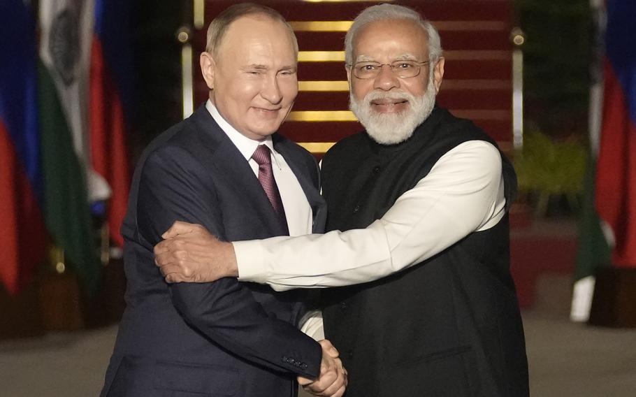Russian President Vladimir Putin, left, and Indian Prime Minister Narendra Modi greet each other before their meeting in New Delhi, India on Dec. 6, 2021. 