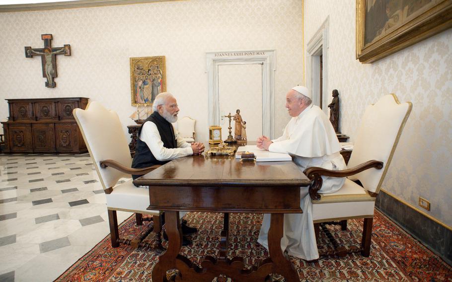 India's Prime Minister Narendra Modi, left, sits at a table with Pope Francis on the occasion of their private audience at the Vatican, Saturday, Oct. 30, 2021. Modi is in Rome for the Group of 20 summit. (Vatican Media via AP)