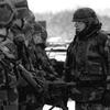 A black and white photo of a man in uniform speaking to other troops.