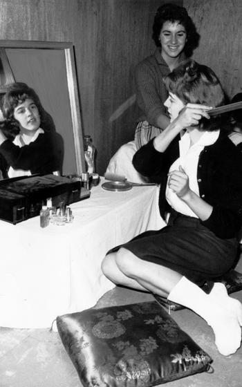 Sue Smee looks on as Cherry LeClear combs her hair. The two girls lived with 9 other girls and 16 boys in Pomeroy Hall while attending nearby American High School on the Seoul Area South Command Post.