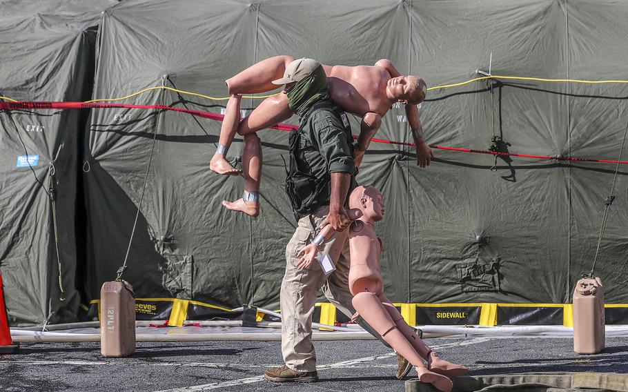 Mike Boyd with L2 Defense a civilian contractor carries some training dummies to the mock contamination area during a nuclear disaster mock exercise in Atlanta on Wednesday, Nov. 2, 2022.