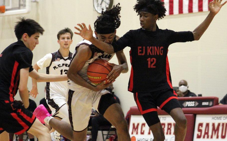 Matthew C. Perry's Shion Fleming finds himself hemmed in by E.J. King's Joshua Foster and Cameron Reinhart during Friday's DODEA-Japan basketball game. The Samurai won 48-42.