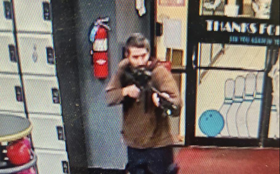 In this image taken from video released by the Androscoggin County Sheriff’s Office, an unidentified gunman points a gun while entering Sparetime Recreation in Lewiston, Maine, on Wednesday, Oct. 25, 2023. Federal and Maine authorities are still searching for the suspected shooter identified as Robert Card, who enlisted in the Army Reserve in December 2002 and was a petroleum supply specialist who had achieved the rank of sergeant first class.