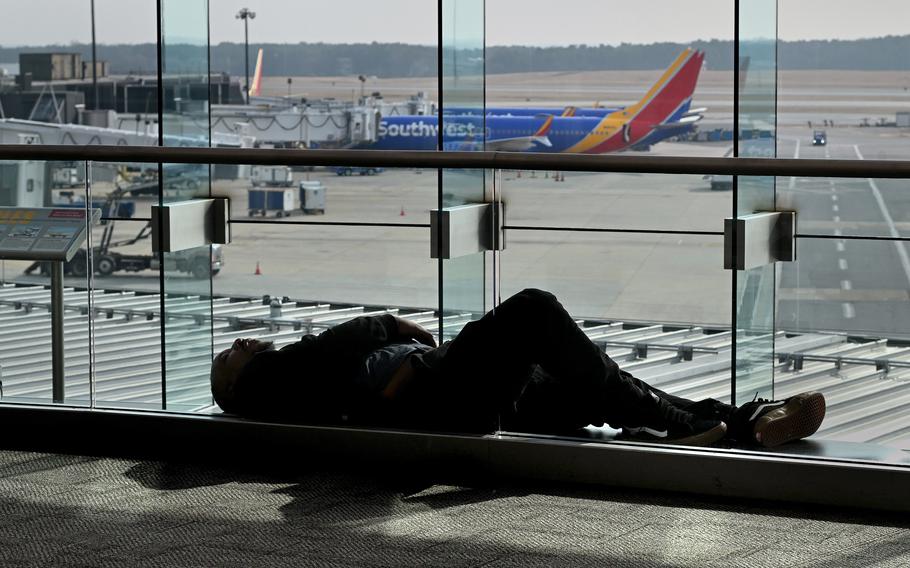 A man rests amid many delays and canceled flights at Baltimore’s BWI on Jan. 11, 2023. 