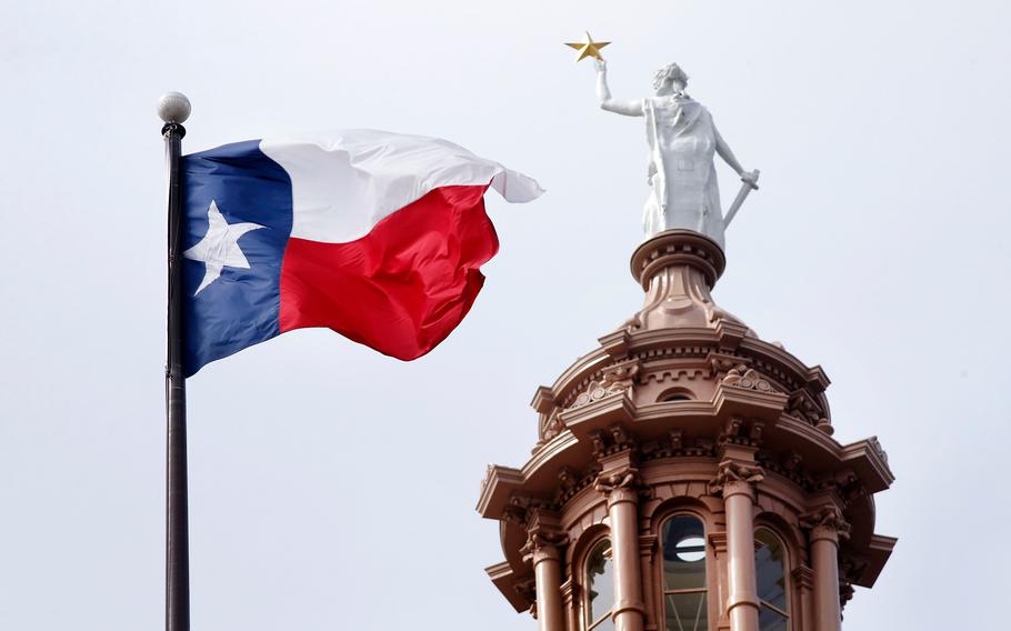 The Texas flag flies over the Texas Capitol.