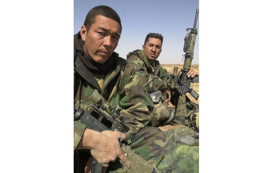 Two men sitting together with weapons