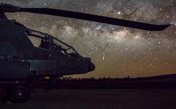U.S. Army AH-64 Apache attack helicopter assigned to 2-6 Cavalry Regiment, 25th Combat Aviation Brigade sits on the flight line while a shooting star falls in the sky on FARP 17, Pōhakuloa Training Area, Island of Hawaii, Hawaii, April 13, 2019. AH-64 Apaches are an integral part of Lightning Strike, a division led, joint live-fire exercise that is conducted under the direction of the multi-domain operations concept. (U.S. Army photo by Capt. Keith Kraker)
