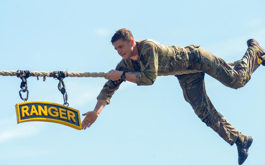 Army Capt. Tanner Potter reaches out to touch the Ranger sign at Victory Pond during the final day of the Army’s annual Best Ranger Competition on Sunday, April 14, 2024, on Fort Moore, Ga. 