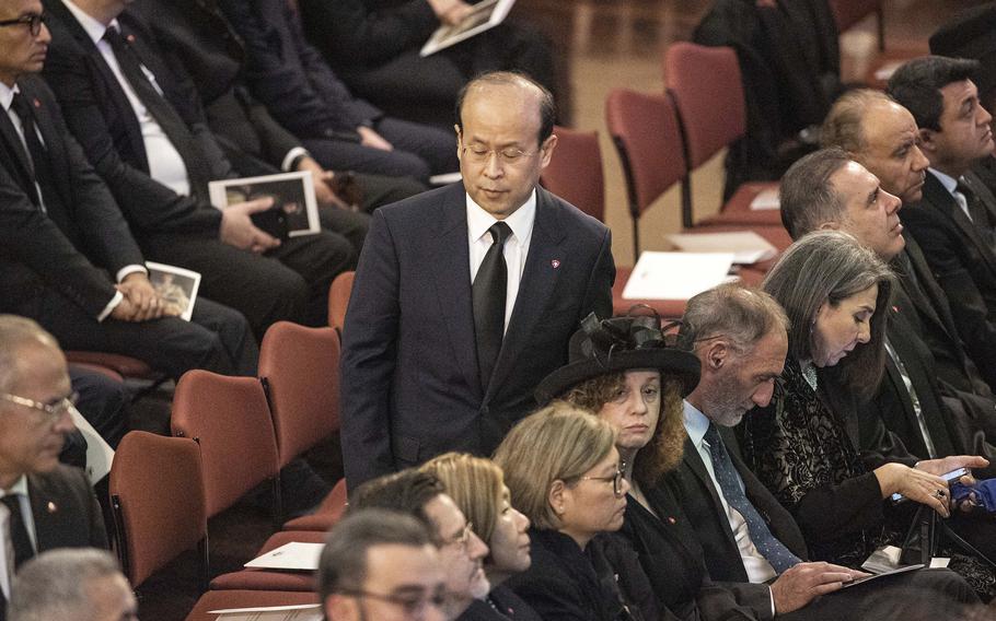 A man standing amid rows of chairs.