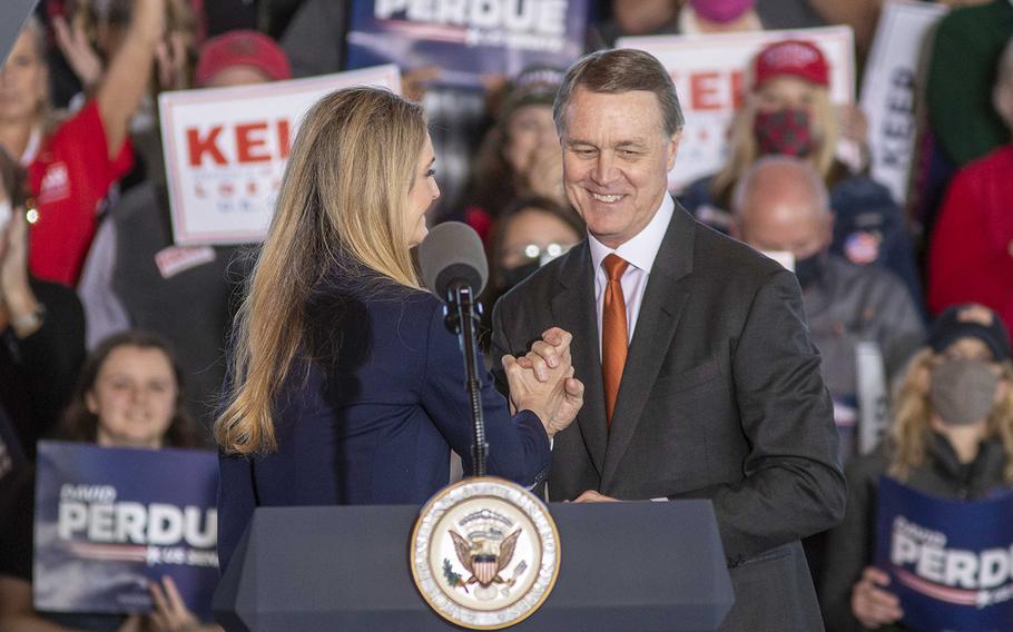 U.S. Sens. Kelly Loeffler and David Perdue embrace after speaking to a crowd at a rally in Gainesville, Georgia, on Nov. 20, 2020. 