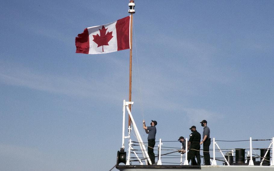 The Canadian flag is raised on the bow of the HMCS Winnipeg as the frigate docks at White Beach Naval Facility, Okinawa, Monday, Nov. 15, 2021. 