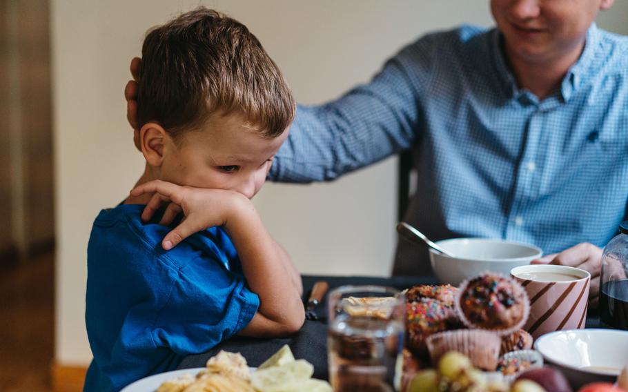 Riumin Dmytro and his son, Ilya, eat breakfast before school. 