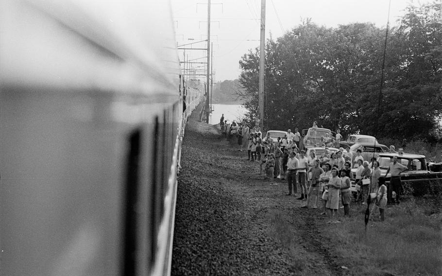 People stand near railroad tracks as a train carries the body of Robert F. Kennedy from New York to Washington, D.C., on June 8, 1968.