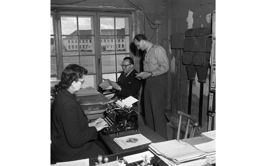 Johannes Jlihkam (seated), chief of children’s archives for the International Tracing Service, discusses a case with one of his employees as a clerk types at the ITS’ offices in Esslingen, in Baden-Wuerttemberg. 