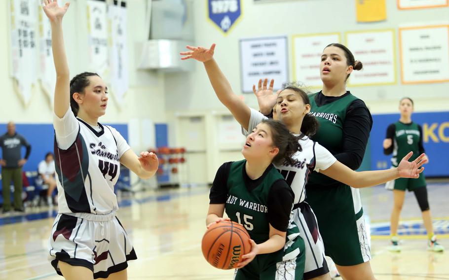 Daegu's Denali Clites drives between Perry defenders Sophia Nye and Layla Springs. The Warriors won 39-20.