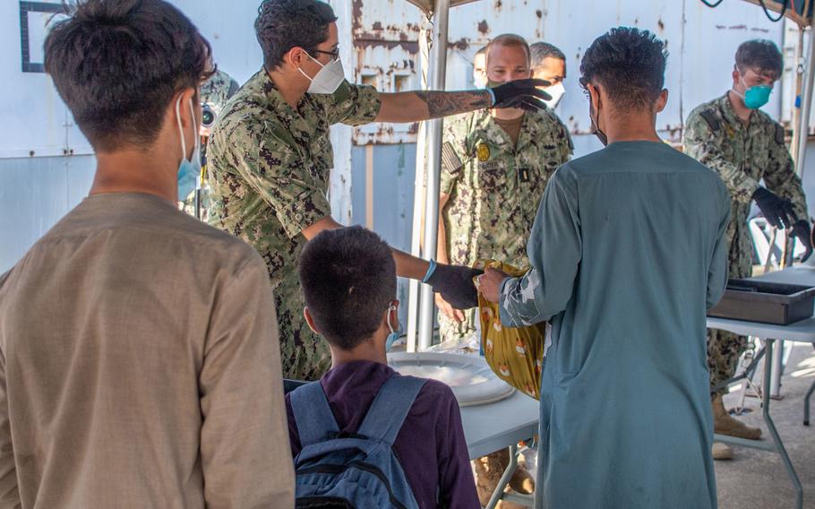 Evacuees from Afghanistan move through a security checkpoint Friday, Aug. 27, 2021, after arriving at Naval Station Rota, Spain.