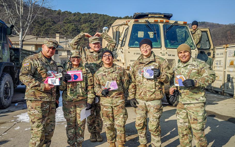 American soldiers pose with their Valentine’s Day cards.