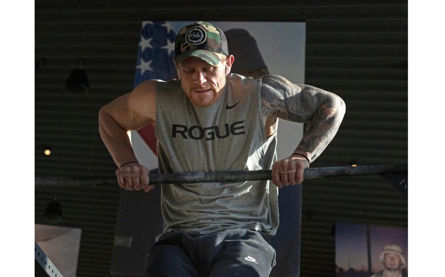 Brandon Tucker, former U.S. Army Ranger from Columbus, Ga., completes his fourth muscle up during his attempt to complete the most in 24 hours for the Guinness Book of World Records at the National Veterans Memorial and Museum in Columbus, Ohio, on Sunday, Jan. 30, 2022. 