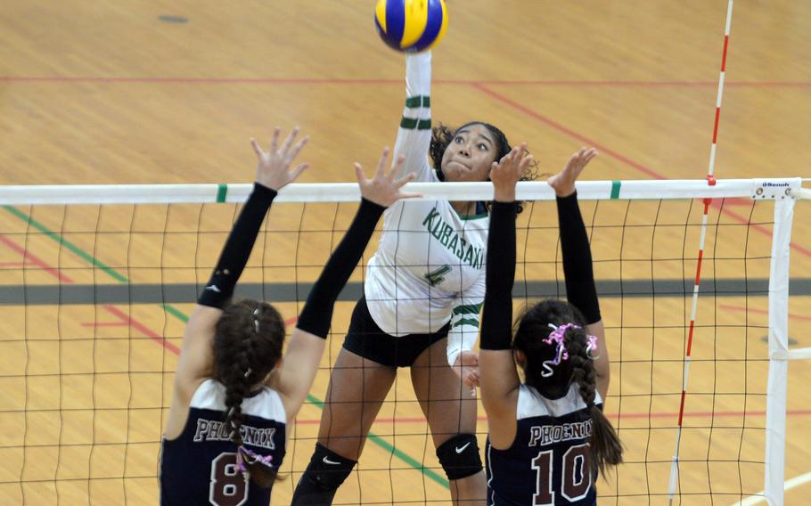 Kubasaki's Risha McGriff spikes between Seisen's Lisa Purcell and Aina Sekido.