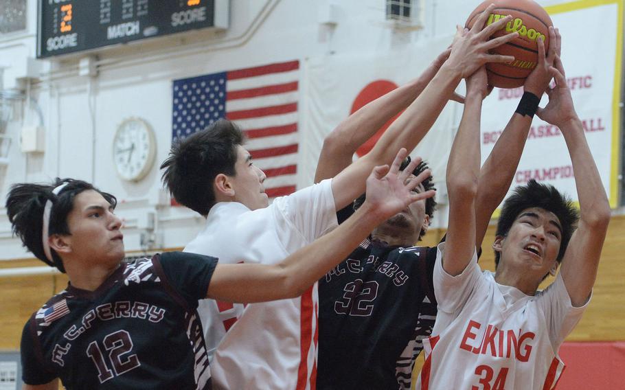 Matthew C. Perry's Nicko Elizondo and Jayden Puju and E.J. King's Cameron Reinhart and Nolan FitzGerald tussle for a rebound during Friday's DODEA-Japan basketball game. The Cobras won 73-58.