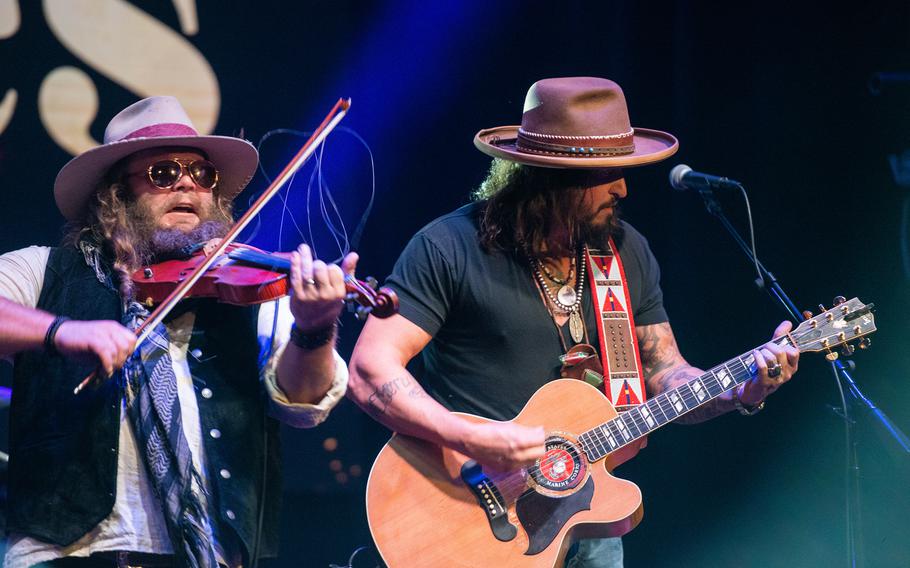 The country music duo War Hippies — Marine veteran and guitarist Scooter Brown, right, and Army veteran and violinist Donnie Reis, left — perform March 9, 2023, at MadLife Stage & Studios in Woodstock, Ga., just north of Atlanta. Brown and Reis both served in Iraq before embarking on music careers after leaving the military.