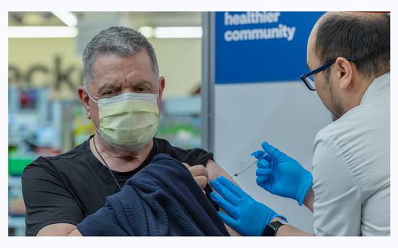 Pharmacist Aaron Sun administers a COVID-19 vaccine to John Vuich at CVS Pharmacy in Eagle Rock, Calif., on Sept. 14, 2023.