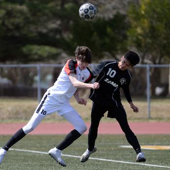 Nile C. Kinnick's Ryo Nishiyama and Zama's Gabriel Rayos try to head the ball during Saturday's DODEA-Japan soccer match. The teams battled to a 1-1 draw, the first non-win for Kinnick since April 20, 2019.