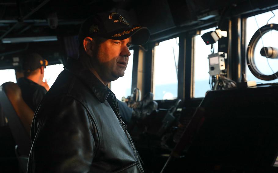 Cmdr. Charles Cooper stands watch on the bridge of the guided-missile destroyer USS Rafael Peralta in the Taiwan Strait, Thursday, Nov. 2, 2023.