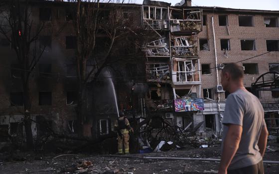 A man surveys damage to an apartment complex.