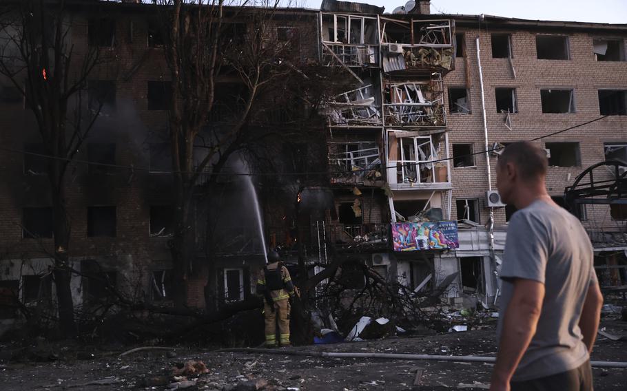 A man surveys damage to an apartment complex.