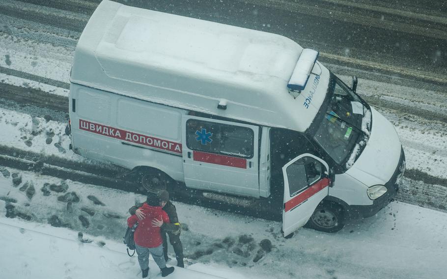 An ambulance staff member and a resident embrace in downtown Kharkiv.