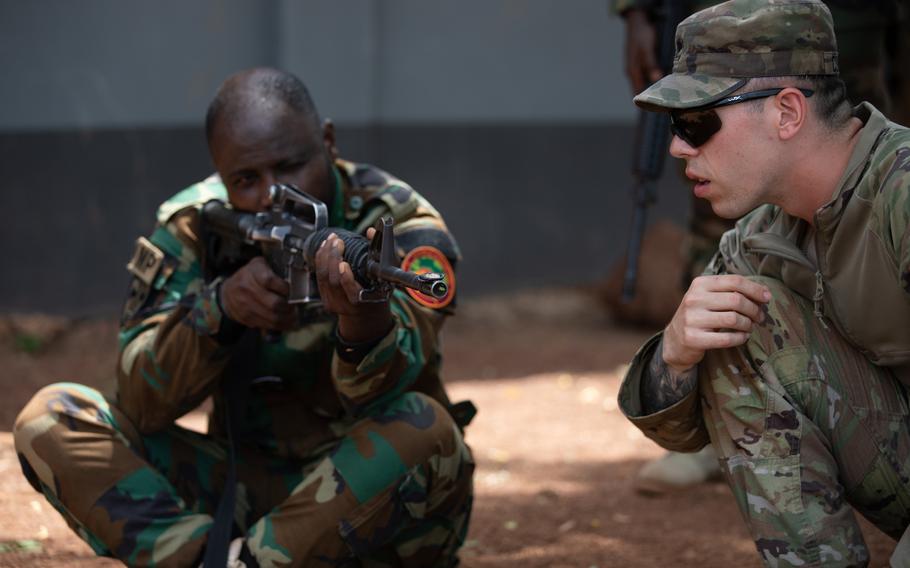 U.S. Army Spc. Clayton Cummings from the 527th Military Police Company, Hohenfels, Germany, instructs Staff Sgt. Ali Abdul-Basit of the Ghana military police in marksmanship skills during African Lion 2023, in Daboya, Ghana, June 7, 2023. Approximately 8,000 personnel and 18 nations are participating in the exercise.