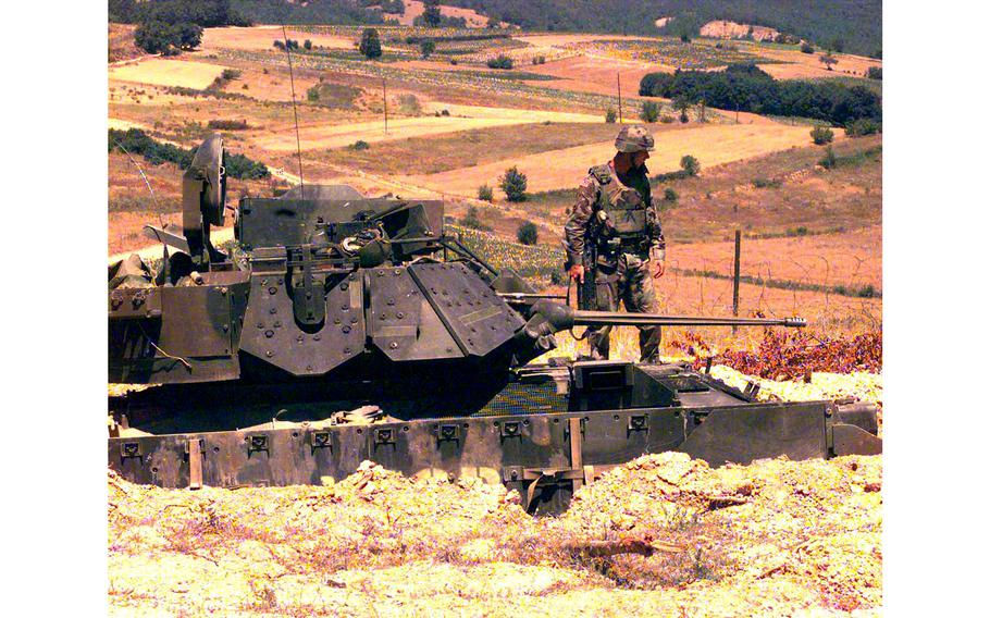 Sgt Michael Gibson, with 1st Battalion, 36th Regiment, checks out an Army tank in its defensive position at Check Point Sapper, Kosovo, July 6, 2000.