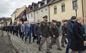 A line of men and women, some wearing service uniforms