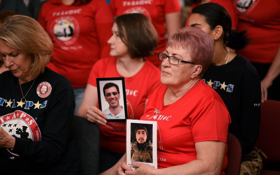 Workers in Dnipro, Ukraine at the headquarters of TAPS-Ukraine hold up photos of family members they've lost since the Russian invasions in 2014 and in February this year. Bonnie Carroll, president of the military survivors' resource TAPS, is on the left. She was in Ukraine during a 10-day visit.