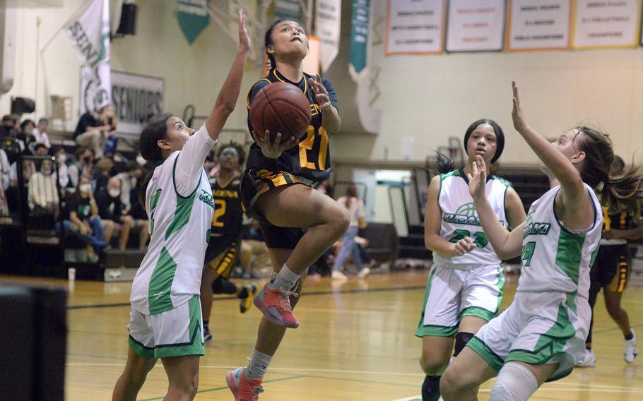 Kadena's Shyrelle Riley drives for a shot between Kubasaki's Syra Soto, Alannah Ridgway and Jacquilline Mitchell during Thursday's Okinawa girls basketball game. The Panthers won 43-8.