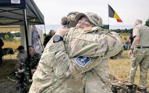 Uniformed troops share a congratulatory embrace.