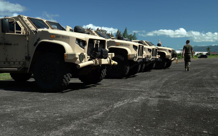 A U.S. Marine walks past joint light tactical vehicles during a Balikatan drill at Naval Base Camilo Osias, Philippines, March 26, 2022. 