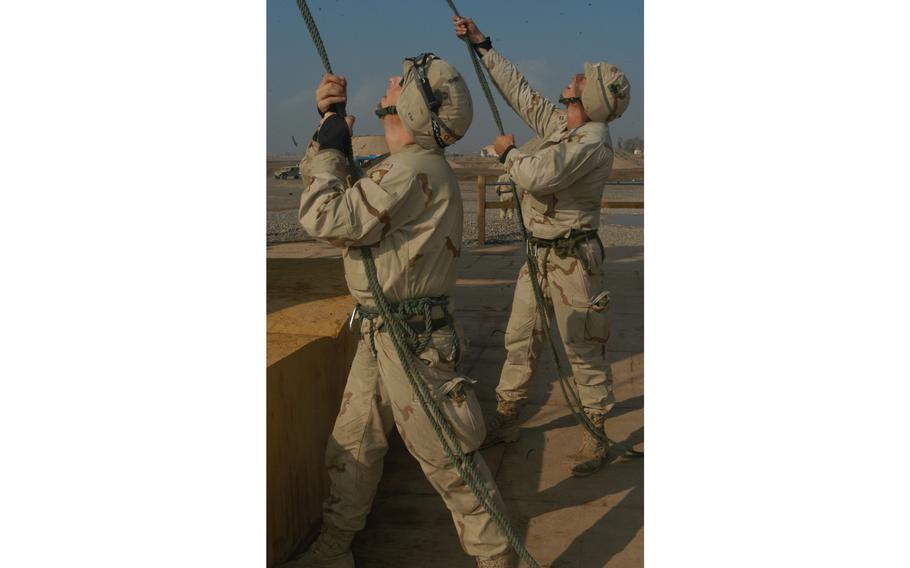 Soldiers belay (secure) the ropes of fellow students at they rappel down a tower at the 101st Airborne Division’s air assault school at Qayyarah West Air Field in northern Iraq. At left is Spc. James Cox, 20, from Mountain Home, Ark.; right, Pfc. Robert Ferry, 23, from Pittsburgh. Both are infantrymen with the 1st Battalion, 327th Infantry Regiment, 1st Brigade Combat Team.