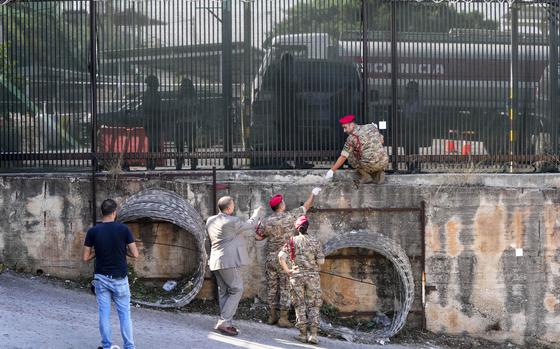 Lebanese Army investigators inspect bullet holes and collect forensic evidence next to the entrance of U.S. Embassy in Aukar, a northern suburb of Beirut, Lebanon, Thursday, Sept. 21, 2023. Lebanon's security agencies have launched an investigation into a late night shooting outside the U.S. embassy in Lebanon that caused no injuries, officials said Thursday. (AP Photo/Hassan Ammar)
