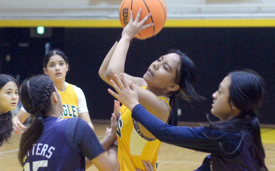 Robert D. Edgren's Maliyah Magat drives between Academy of Our Lady of Guam defenders during Thursday's pool game in the 5th American School In Japan Kanto Classic basketball tournament. The Cougars won 32-11.