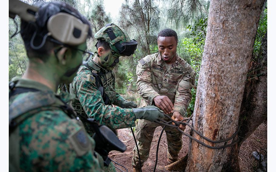 Members of the 25th Infantry Division train side by side with Singapore Armed Forces partners on May 11, 2023 during Tiger Balm 23 on the steep Hawaiian mountainsides, deep in the jungle. 