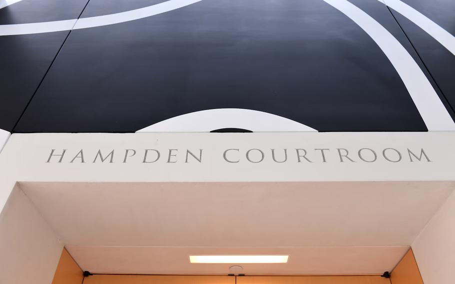 The text “Hampden Courtroom” is seen above a door.