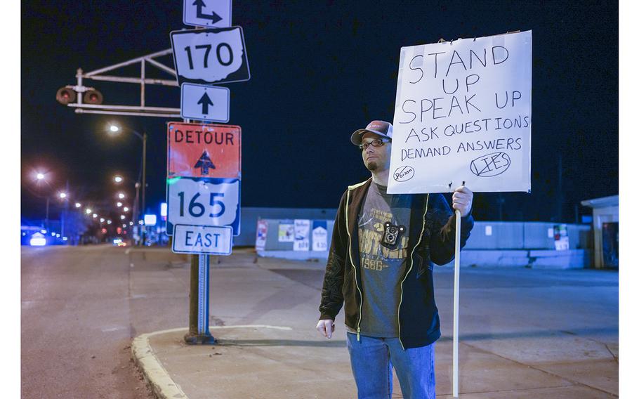 Randy DeHaven holds a sign encouraging residents to seek information.