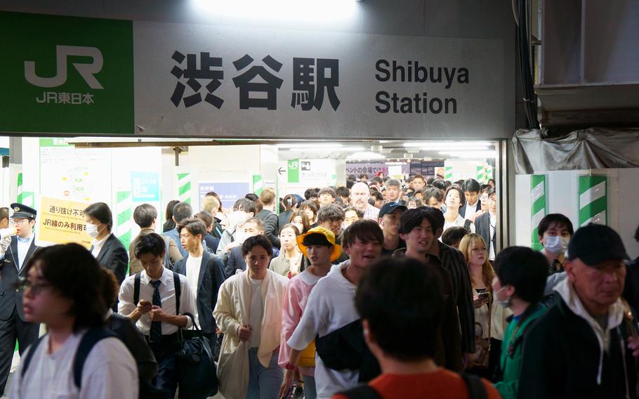 Halloween revelers and commuters stream out of Shibuya Station in Tokyo, Tuesday, Oct. 31, 2023. 